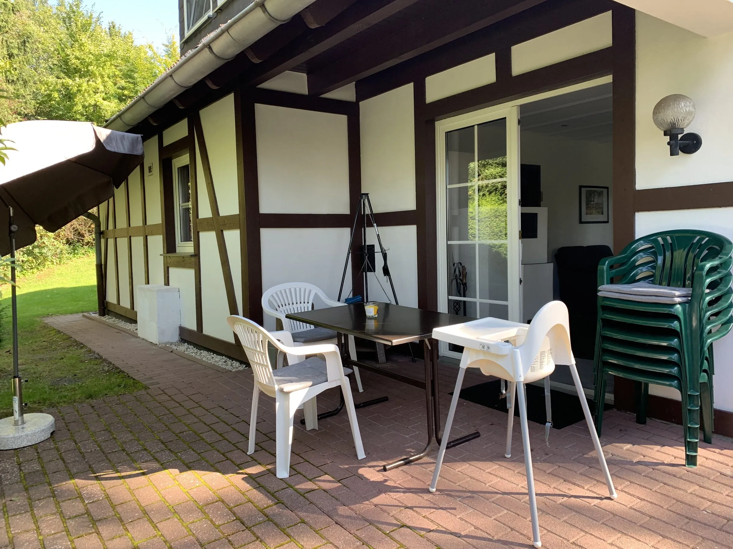 Terrasse entlang der Hauswand mit Sitzgruppe und Hochstuhl